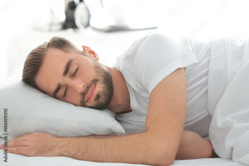 Morning of handsome man sleeping in bed at home