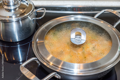 Closeup view misted up pan lid cooking on modern electric cooker