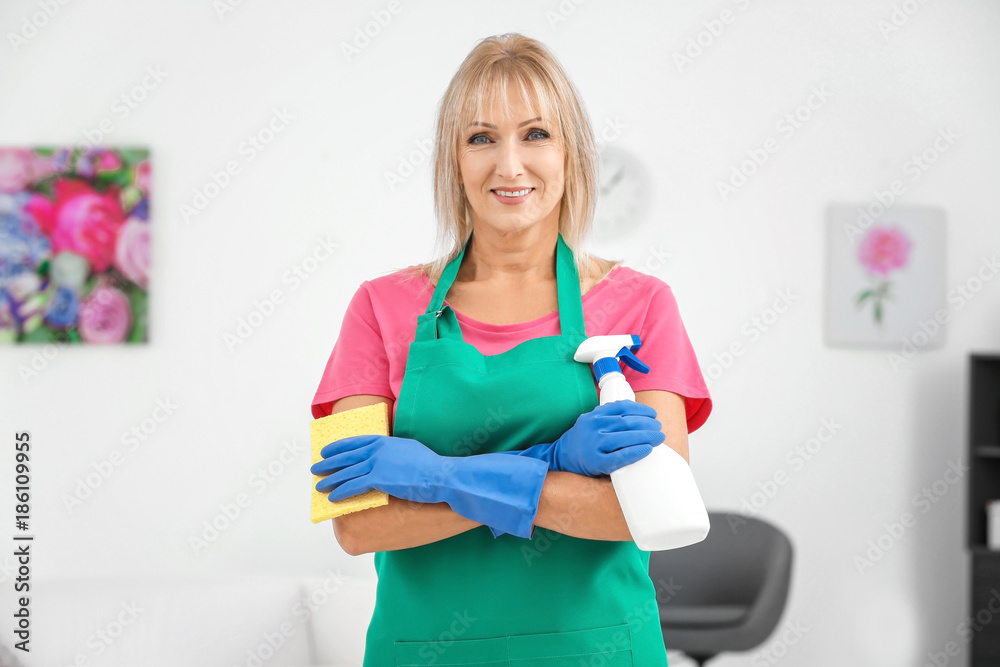 Mature woman with bottle of detergent and sponge at home Mature woman with bottle of detergent and sponge at home