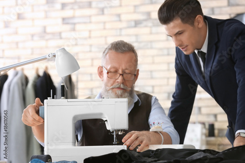 Senior tailor working on se...