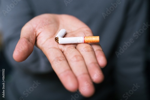  male hand crushing no smoking cigarette. Quitting from addiction concept.
