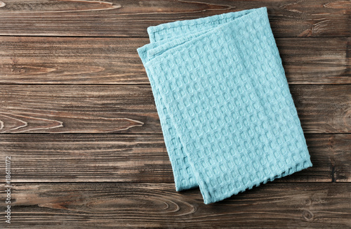 Clean kitchen towel on wooden table, top view