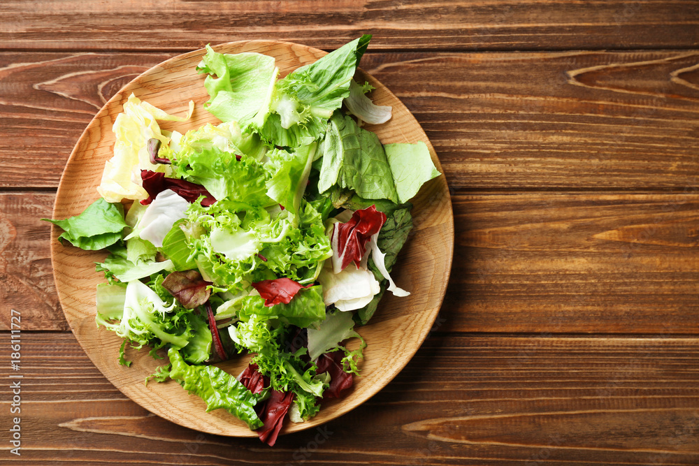 Plate with fresh salad on table