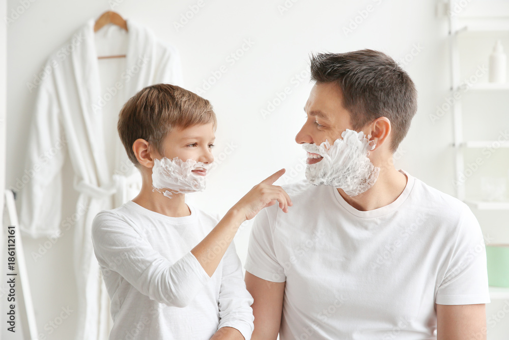 Father and son shaving together in bathroom Father and son shaving together in bathroom