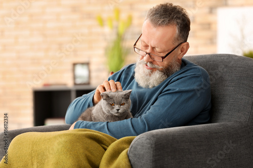 Senior man holding cute cat...
