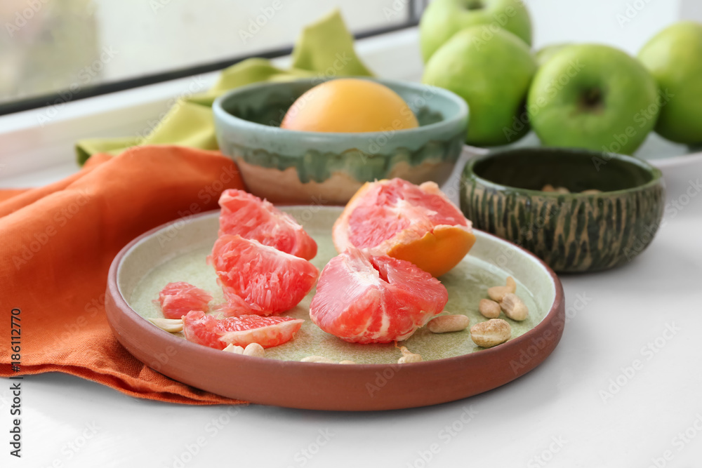 Plate with grapefruit on windowsill Plate with grapefruit on windowsill