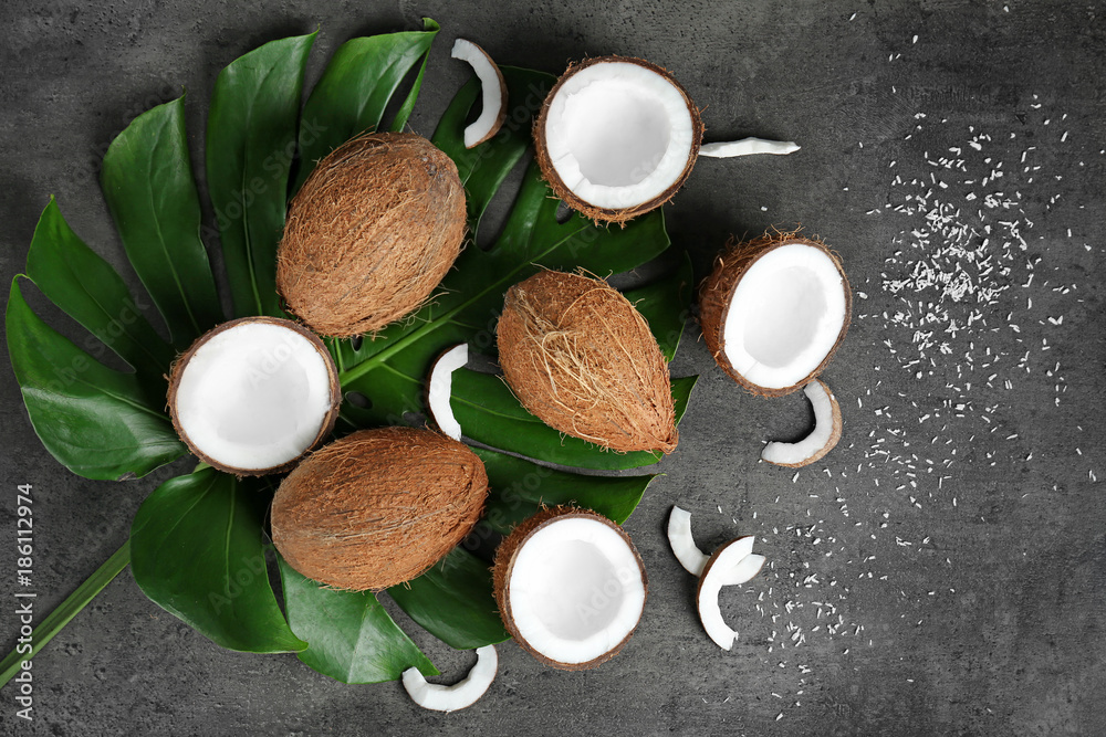Composition with green leaf and fresh coconuts on grey background