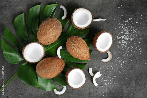 Composition with green leaf and fresh coconuts on grey background