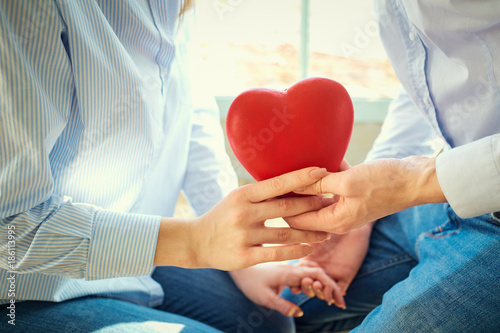 Heart in the hands of a young couple close-up. Concept Valentine's Day.