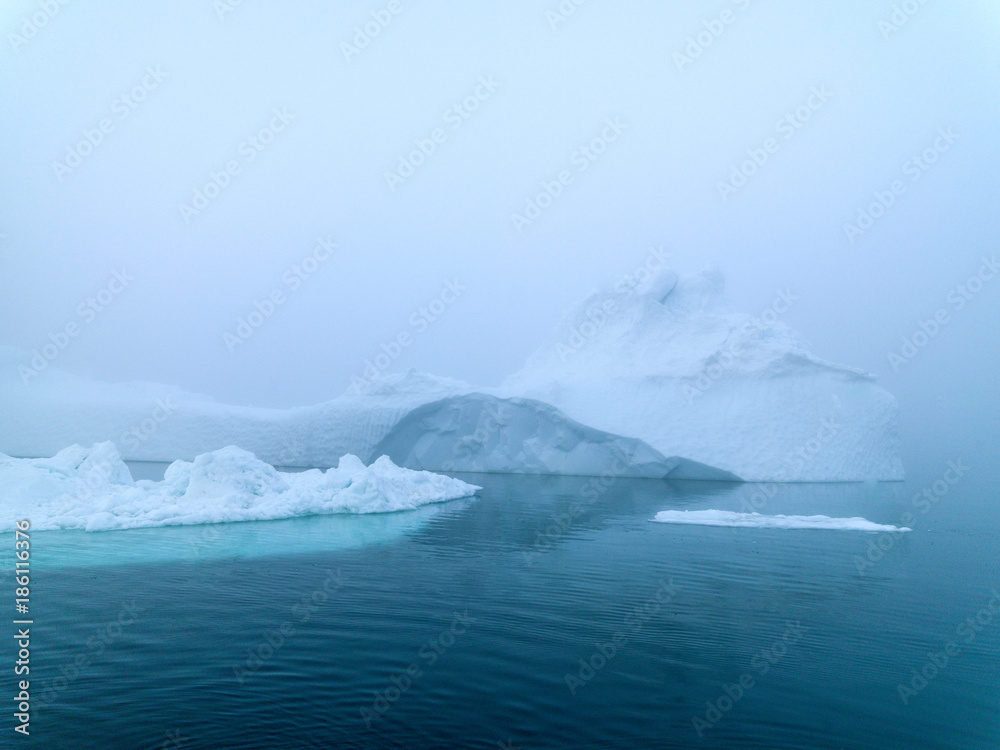 Icebergs in foggy day on Arctic Ocean in Greenland Icebergs in foggy day on Arctic Ocean in Greenland