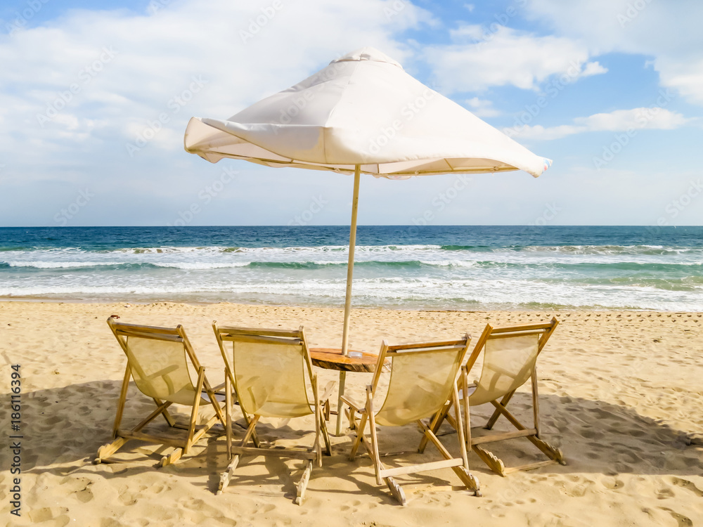 Beach chairs and umbrella on the sea coast