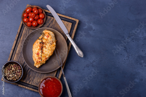 Breast chicken and ketchup on cutting board