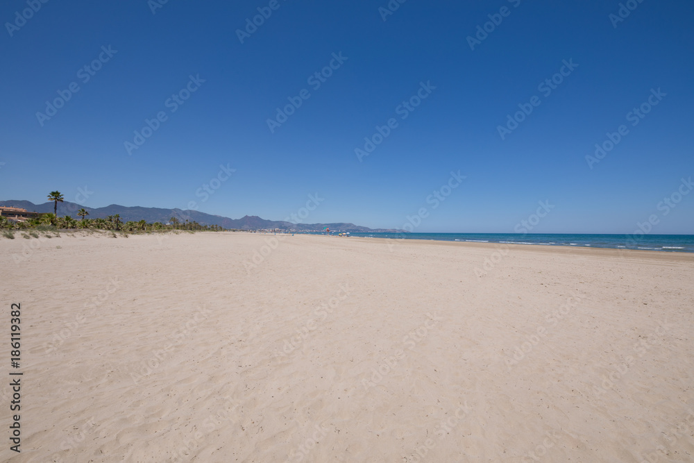 landscape beach of Grao of Castellon named PIne or Pinar, in Valencia, Spain, Europe. Blue clear sky, Mediterranean Sea and Benicassim in the horizon
