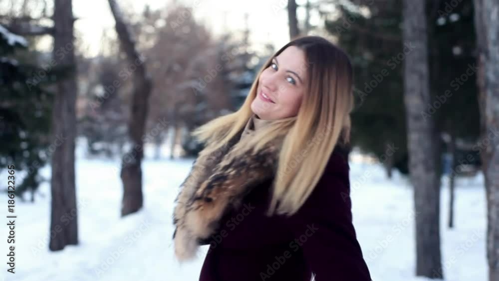 A beautiful girl turns around herself against the backdrop of a winter forest A beautiful girl turns around herself against the backdrop of a winter forest