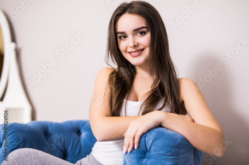 Young beauty woman at home sitting on modern chair at home