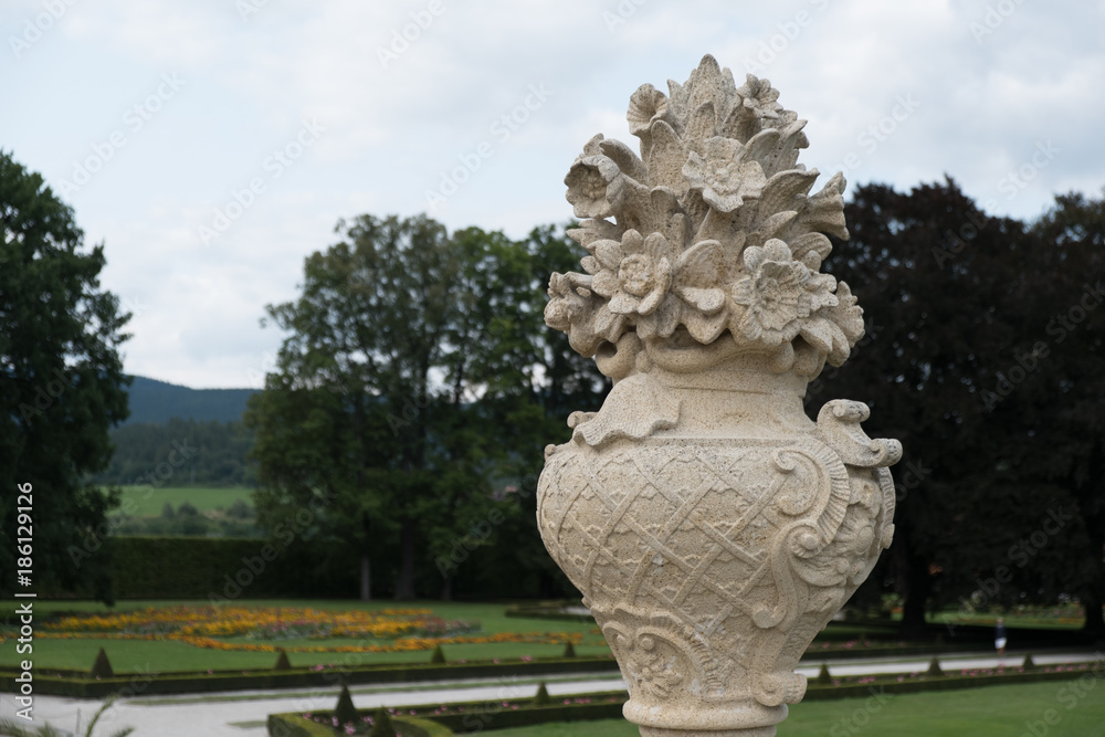 Obraz premium Elaborately carved vase with flower with View of the Castle Gardens at Cesky Krumlov from the upper terrace.