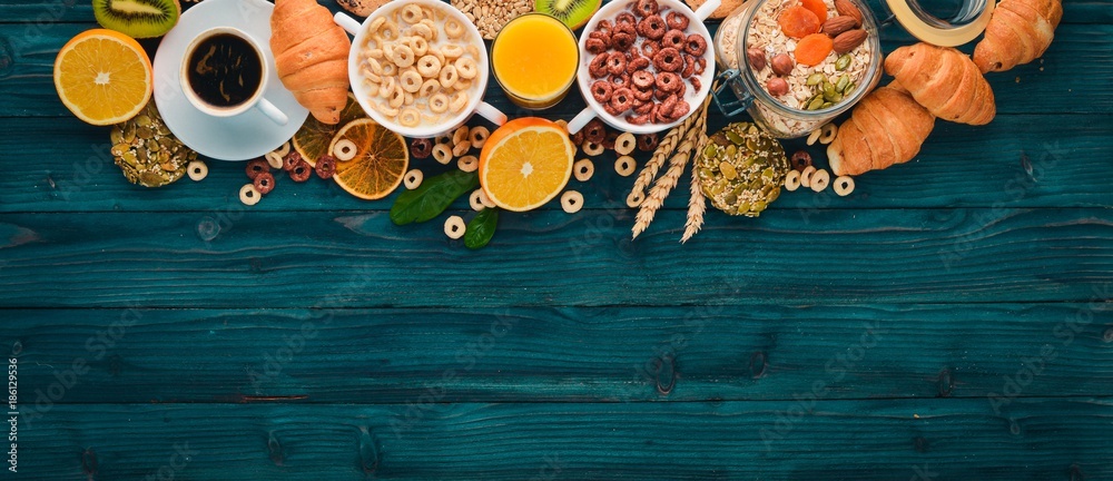 Fototapeta Breakfast served with coffee, orange juice, croissants, cereals and fruits. Balanced diet.