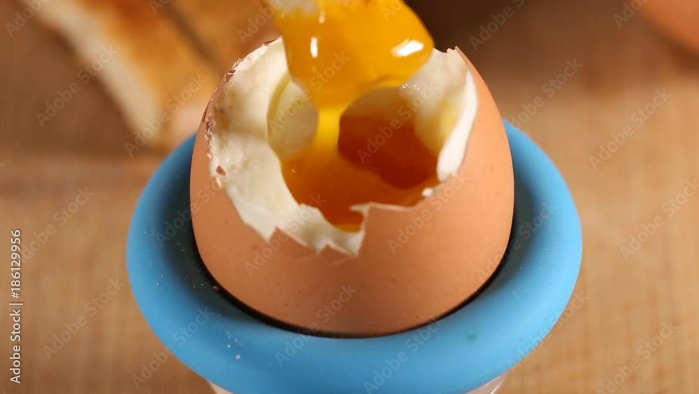 Eating yolk form boiled egg with toast