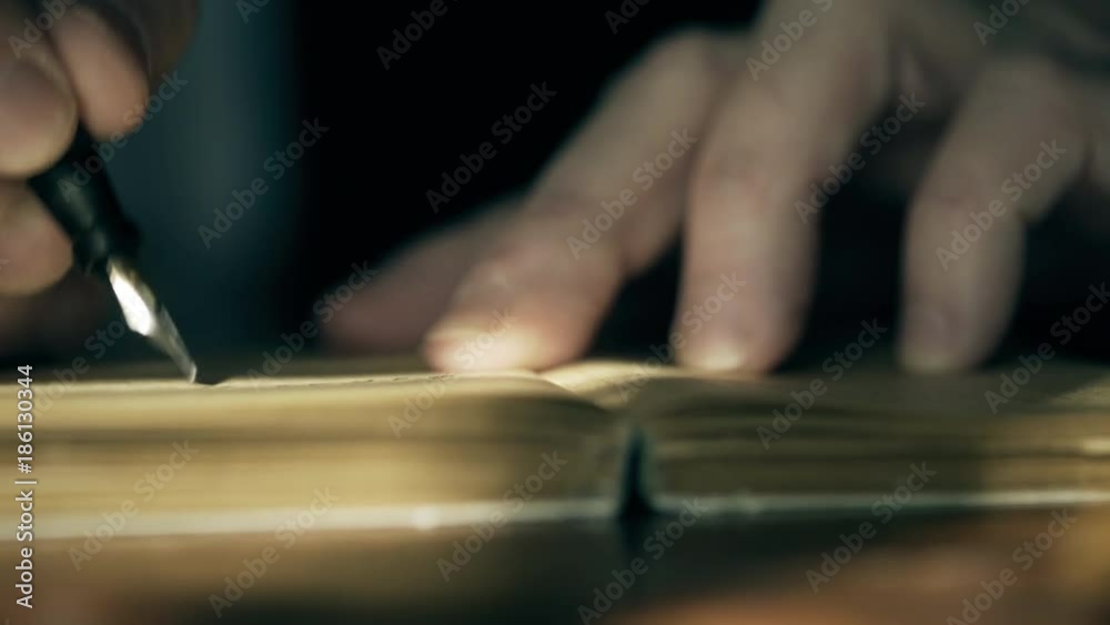 Macro shot of a Caucasian businessman in 1930 making entries into a business ledger or engaged in handwritten communication using a fountain pen. Macro shot of a Caucasian businessman in 1930 making entries into a business ledger or engaged in handwritten communication using a fountain pen.
