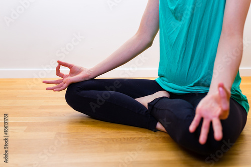 girl sitting in yoga pose meditate on the floor