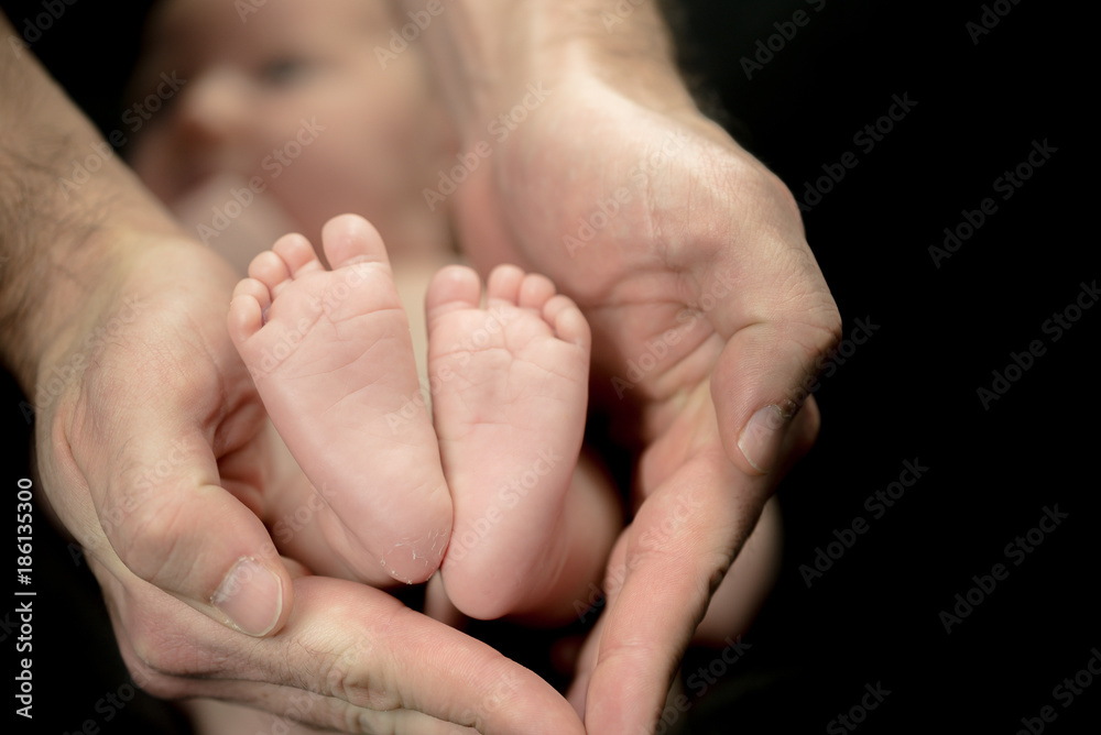 Newborn Baby feet in parents' hands - happy family moments of parents with their children Newborn Baby feet in parents' hands - happy family moments of parents with their children