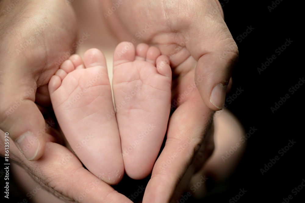 Newborn Baby feet in parents' hands - happy family moments of parents with their children Newborn Baby feet in parents' hands - happy family moments of parents with their children