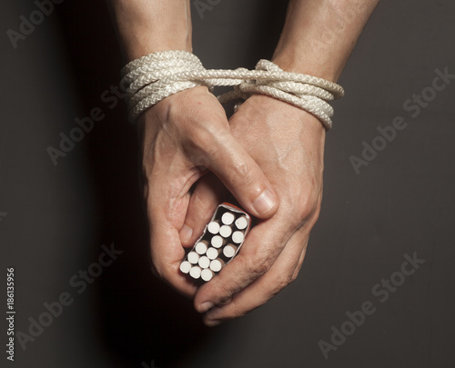 Tobacco addiction. Cigarettes on male hands tied with a rope