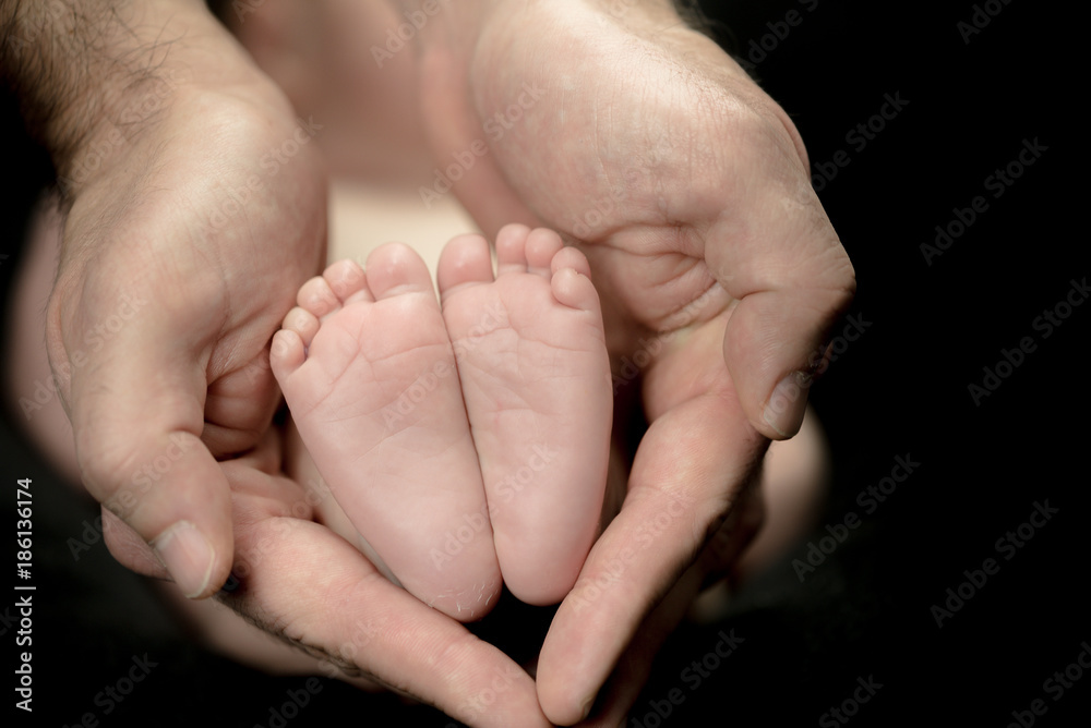 Newborn Baby feet in parents' hands - happy family moments of parents with their children Newborn Baby feet in parents' hands - happy family moments of parents with their children