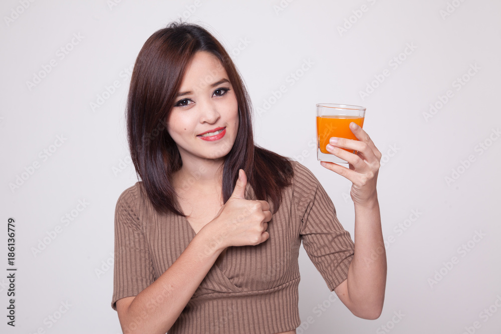 Young Asian woman thumbs up drink orange juice. Young Asian woman thumbs up drink orange juice.