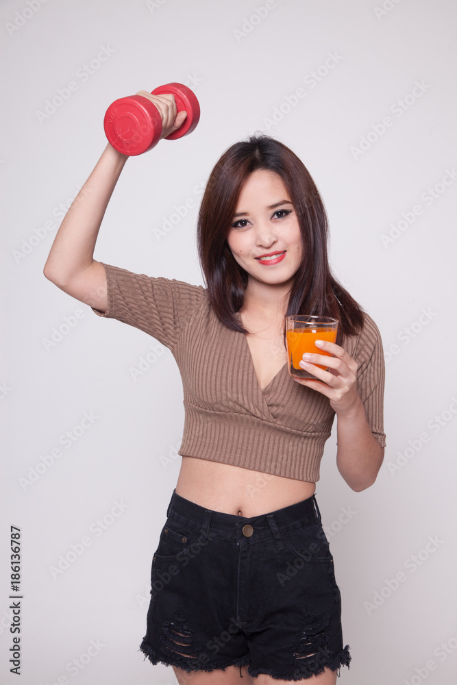 Young Asian woman with dumbbell drink orange juice. Young Asian woman with dumbbell drink orange juice.