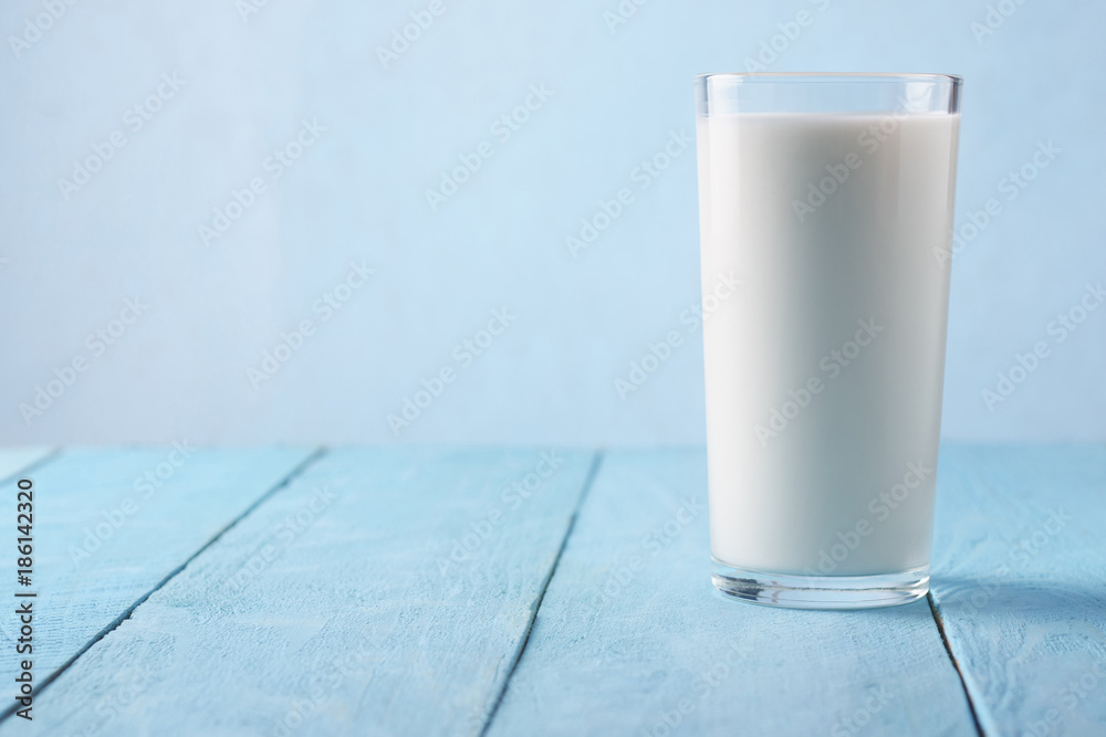 Milk in a glass on a blue background Milk in a glass on a blue background