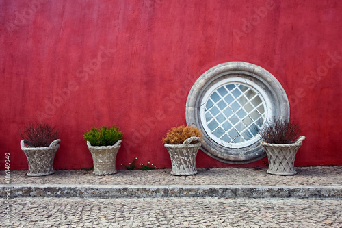 colored red house with a round window in summer in Portugal