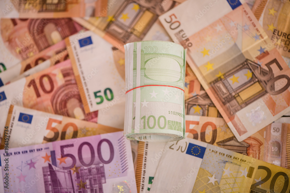 Obraz premium rolled up one hundred euro notes bills on money background