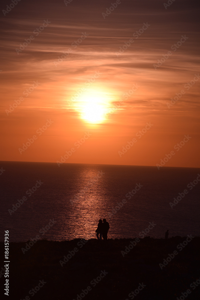 Sun sets over couple taking a romantic stroll