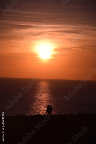 Sun sets over couple taking a romantic stroll