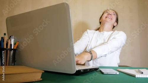Young woman very quickly typing on a laptop with a facial expression like mad. Heavy work of freelancer.