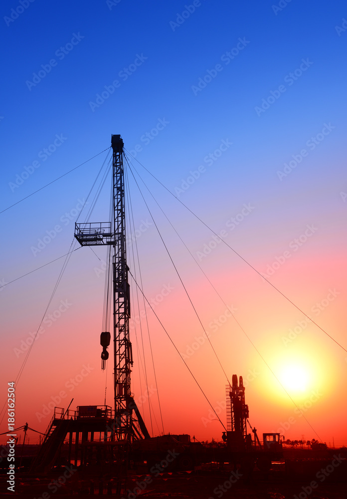 Is operation of pumping unit under the sunset of oilfield, close-up