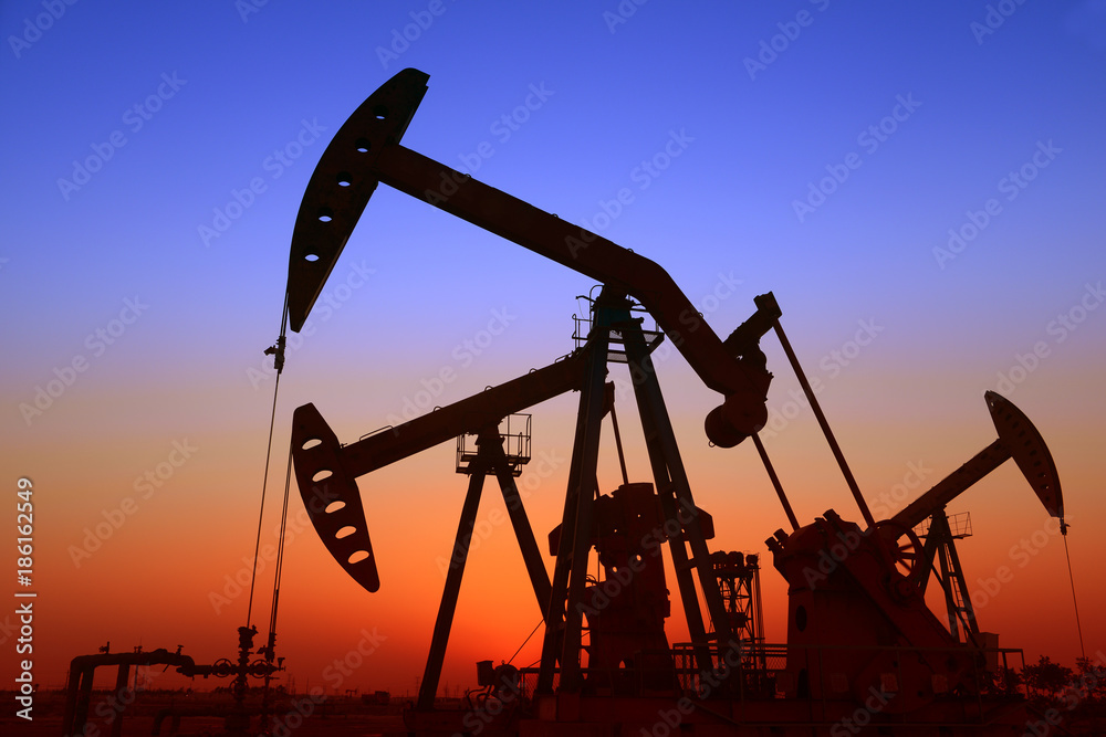 Is operation of pumping unit under the sunset of oilfield, close-up Is operation of pumping unit under the sunset of oilfield, close-up