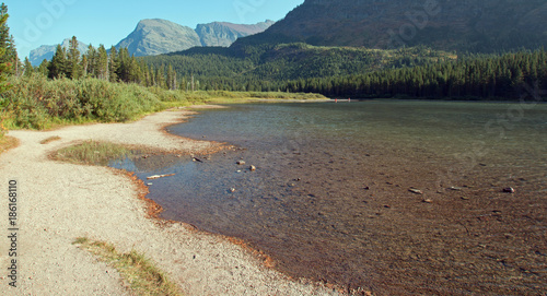 Irregular shoreline of Fishercap Lake on the Swiftcurrent hiking trail in the Many Glacier region of Glacier National Park during the 2017 fall fires in Montana United States photo