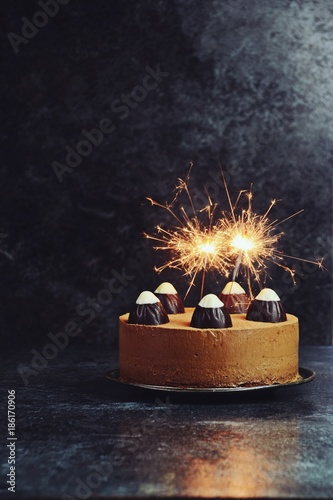 Chocolate cake with sparklers on the dark background