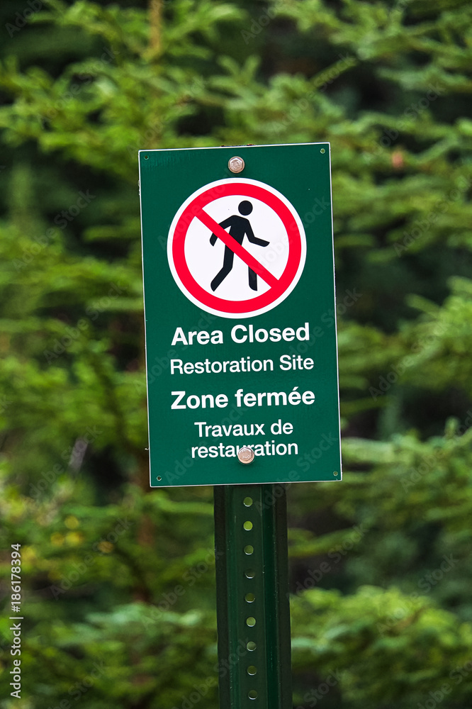 A green sign indicating area closed as a restoration site A green sign indicating area closed as a restoration site