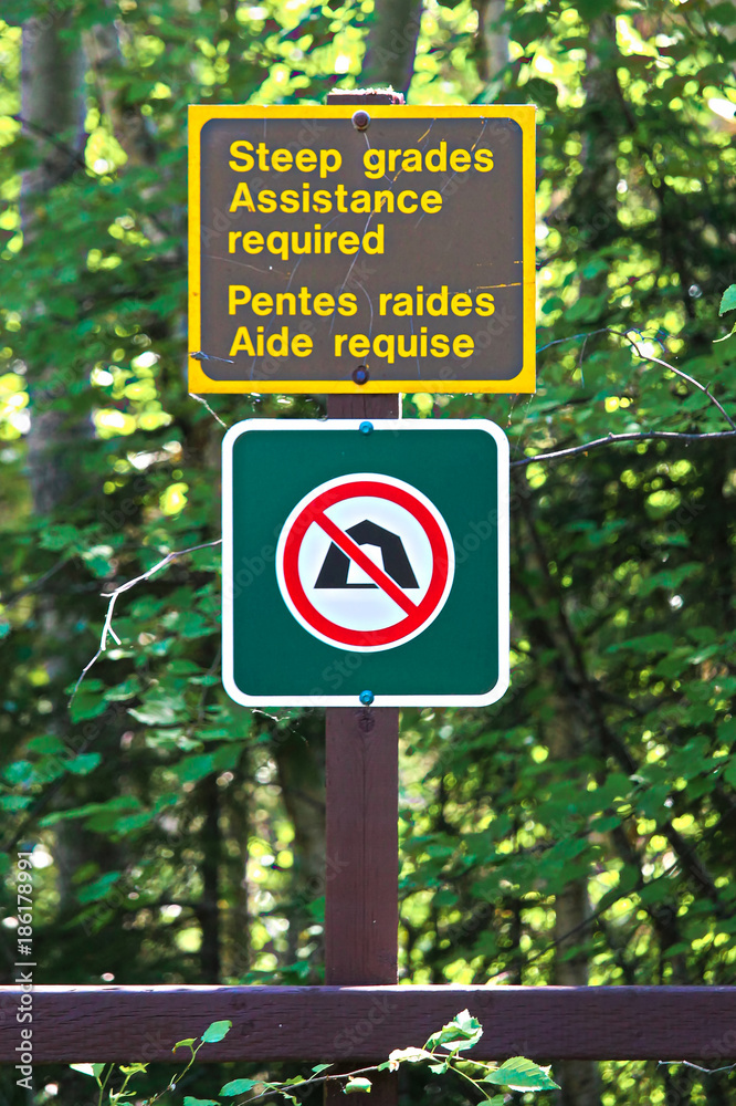 Steep grades assistance required and a no camping sign