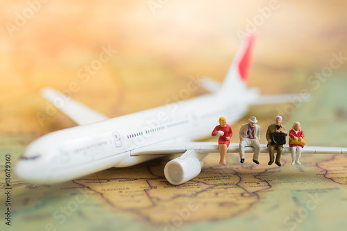 Miniature business people : businesses team waiting for airplane with copy space for travel around the world, business trip traveler adviser agency or online world wide marketing concept.