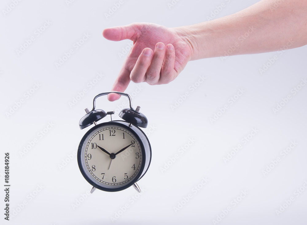 alarm clock or alarm clock with hand on the background. alarm clock or alarm clock with hand on the background.