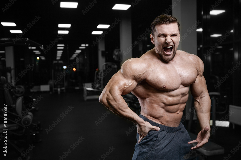 Fototapeta premium Brutal strong bodybuilder athletic men pumping up muscles with dumbbells.