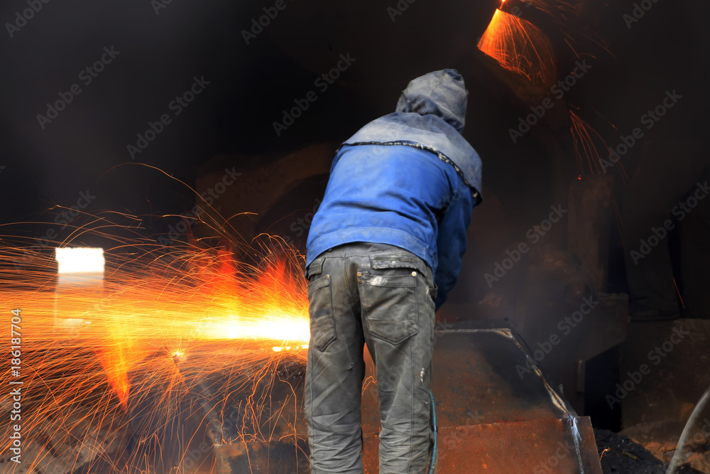 The workshop welder cuts metal值）