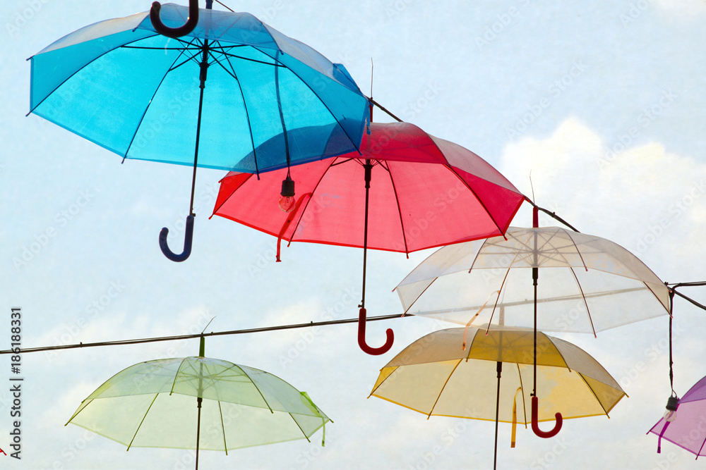 multicoloured umbrellas and cloudy blue sky