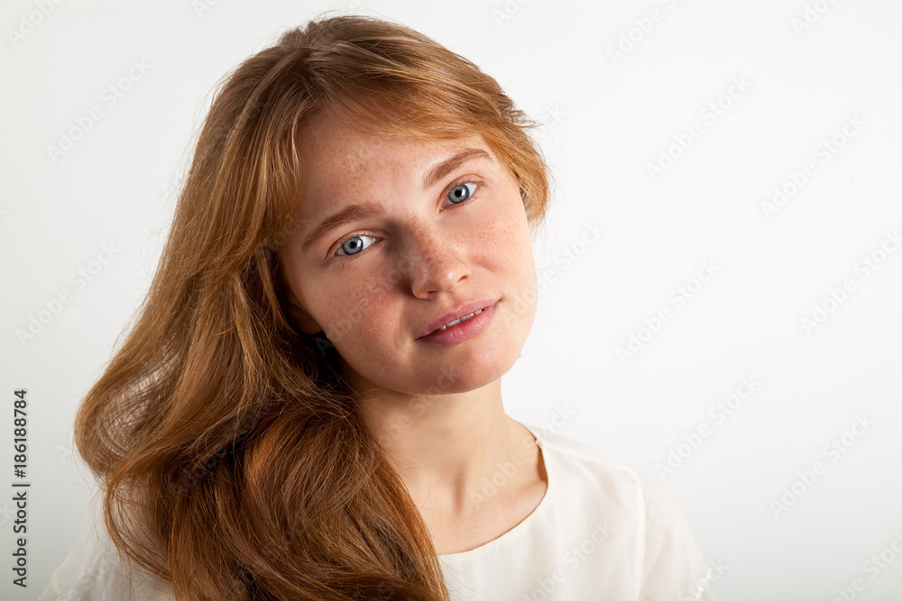 Close up portrait of beautiful red-headed lady with forelock, freckles and blue eyes looking at the camera with confidence. Natural beauty concept. White background, copy space Close up portrait of beautiful red-headed lady with forelock, freckles and blue eyes looking at the camera with confidence. Natural beauty concept. White background, copy space