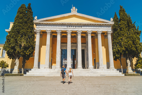 Two people walking to building Zappeion Megaron in the National Gardens of Athens, Greece. photo