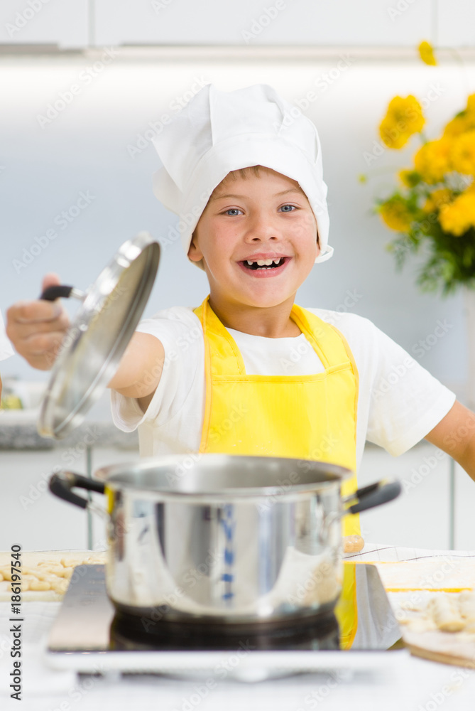 Happy little boy opened the lid on the pan Happy little boy opened the lid on the pan